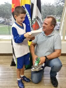 Davi, de apenas 8 anos, foi vice-campeão da modalidade “Basquete” e levou para casa um troféu e um tablet de 10 polegadas. A entrega dos prêmios foi realizada na manhã de sexta-feira (22/11), na presença do prefeito Cláudio Schooder (o Leitinho) e do secretário municipal de Educação, José Jorge Teixeira.